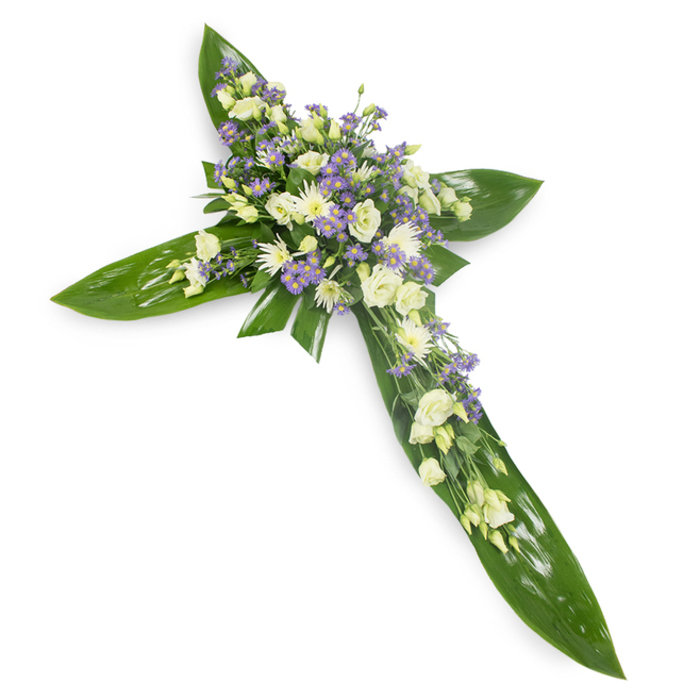 In this centred, quietly reverent floral cross the florist's hand is evident in the balance of foliage and bloom; photographed from a slightly elevated angle on a stark white backdrop, the design feels almost like a small sanctuary of flowers. Large, glossy green tropical leaves - Ti-like in scale and sheen - are layered to construct the cross's arms and central shaft, their deep green and defined veins giving weight and a protective feel. At the crossroads of the design and along the horizontal and vertical axes, clusters of cream and white lisianthus rise with soft, cup-shaped petals, accompanied by tight white chrysanthemum or spray rose clusters that catch the light with a soft gleam. Intermittent sprays of pale purple or lavender limonium/asters lend a delicate, cooling counterpoint, as though a soft ribbon of twilight has been threaded through the blooms. Thin, lighter green filler stems are tucked in between, adding feathered texture and the suggestion of a garden breeze. The lighting is neutral and even, highlighting the tender translucency of petals and the satiny glow of leaves. Intended as a sympathy or memorial tribute, the piece conveys solace and understated faith; I can imagine it placed in a church near Dartmouth Park or delivered for a service in Tufnell Park, offering family and friends a composed, heartfelt expression of remembrance that reads both spiritual and serenely human.
