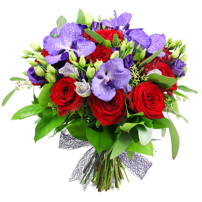 An opulent hand-tied arrangement of deep red roses and striking purple Vanda orchids dominates the scene against a pristine white backdrop, its mood luxurious and celebratory. The velvety red blooms are fully open, their petals curling into tight spirals that catch the light with a wine-dark sheen, while the Vanda orchids spread across the center in broad petals mottled with delicate purple speckles, adding exotic texture. Interspersed there are clusters of lisianthus in soft lilac, some just opened, others in gentle bud form, providing lighter, silvery touches that soften the intensity. The bouquet is lush with greenery: large glossy leaves create a rich backdrop, and slender sprigs of filler foliage add movement and air. The stems are neatly gathered at the base and tied with a dark, almost black or deep plum mesh ribbon, its open weave lending architectural interest and a contemporary edge to the classic floral shapes. This arrangement feels crafted for grand occasions-anniversaries, Valentine style celebrations, or elegant gifts-while still fitting comfortably as a dramatic centerpiece at a dinner party or in a stylish home near Fortess Road, Kentish Town, or Archway. It speaks of artistry, precision, and the refined taste of a local florist who prepares every stem with attention to freshness and longevity for same-day delivery across the area.