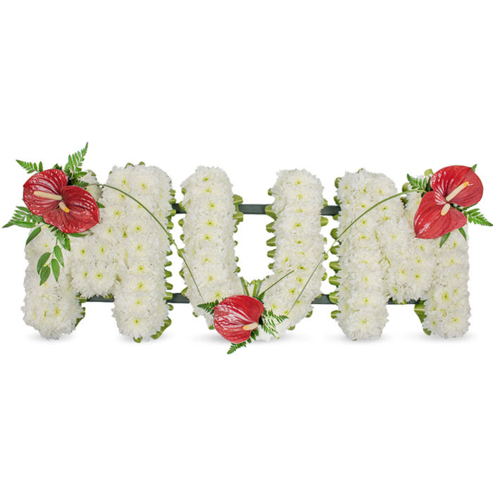 A poignant, handcrafted memorial arrangement spells out MUM in three-dimensional letters set against a neutral background, each letter composed entirely of compact, pristine white spray chrysanthemums. The chrysanthemums read as a continuous, pillowy surface: small rosettes packed so closely that the letters appear soft and luminous, the white petals absorbing light and conveying serenity. The sculpted letters sit upon a barely visible dark-green structural frame that peeks through at the edges, giving honest formality to the design without intruding on the blooms' gentle presence. To animate the composition, three vibrant red anthurium blooms are positioned as focal points-one on the upper left of the first 'M', one resting within the curve of the 'U', and one crowning the upper right of the last 'M'. Each anthurium displays a smooth, glossy spathe and a pale yellow-white spadix, their tropical sheen offering a warm, loving contrast to the matte chrysanthemums. Clusters of deep green foliage, including delicate fern fronds and broader leaves, surround each red bloom, while thin, arching blades of grass connect the accents and create a flowing line across the letters. The overall effect is traditional and tender, a sympathy piece that reads of quiet respect and abiding love. Crafted with the sensibilities of a local florist serving Tufnell Park and nearby Dartmouth Park, this tribute is intended for funeral services, wakes, or graveside placement, providing families with a dignified and heartfelt way to honour a mother's memory.