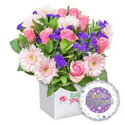 From a sunlit corner of a Tufnell Park shop, this bouquet of pink roses and moonlit gerberas is a jewel of celebration in a clean white presentation box. The roses, in varying stages from snug buds to open crescents of petal, radiate classic romance and a soft perfume that lingers gently in the air. They are joined by light pink gerberas, their petals tipped with white and centers the pale warmth of yellow, lending a buoyant, airy feel. Purple statice clusters punctuate the arrangement, adding pockets of rich colour that draw the eye through the arrangement like a field of confetti. Lush green foliage threads through the stems, providing a lush, garden-fresh texture and a sense of movement. The box itself is minimalist and modern, its white surfaces framing the floral chorus and guiding the eye to the bouquet's colours. Off to one side, a round foil balloon supports the celebration, with a central purple disk bearing 'You're Engaged!' in silver and the playful golden ring forming the 'O' in You're. A white outer ring is edged with tiny pastel hearts and silver stars, echoing the joy of the moment. Crafted with care for couples across NW5-including Tufnell Park-and available for same-day delivery, this design speaks of happiness, commitment, and a bright new journey ahead.