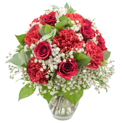 A richly coloured bouquet of classic red and white flowers is captured in crisp detail, standing tall in a clear glass vase against a pure white background that lets every nuance of the design shine. At the heart of the arrangement sit several deep red roses, their velvety petals curled in tight, elegant spirals that suggest quiet passion and timeless romance. Around and between them, abundant crimson carnations, with their many ruffled layers, create a plush, cushion-like texture, giving the arrangement a sense of generous volume and softness. A fine mist of white baby's breath is woven throughout, its tiny clustered blooms forming a light, cloud-like veil that gently breaks up the intensity of the red and introduces a delicate sense of space. The greenery, including the classic glossy leaves of the roses and soft, rounded eucalyptus foliage in muted green tones, offers contrast and natural structure, guiding the eye upward through the dome-shaped composition. The transparent vase, simple and understated with a subtly flared rim, holds straight, neatly cut stems in clear water, reinforcing the impression of careful, professional floristry. Under bright, even light, the reds glow warmly while the whites seem almost luminous, capturing a mood that is both celebratory and comforting. This is the sort of bouquet a local in Tufnell Park might have delivered to a cosy flat near Tufnell Park Road or a café off Junction Road, chosen to mark a special anniversary, a Valentine's surprise, or a heartfelt thinking of you moment that needs no words.