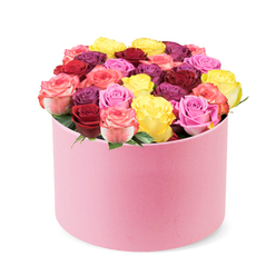 In a bright studio near Tufnell Park, a round pastel pink hat box with a velvet-like finish cradles a lush, domed bouquet. Dozens of freshly bloomed roses rise from the box, their colours arranged in a vibrant chorus: crimson red, magenta, sunny yellow, bubblegum pink, and bi-color petals shifting from pink to cream. The blooms are tightly packed, with little green foliage peeking through to highlight the roses' forms and preserve the box's clean, modern silhouette. The result feels refined and contemporary, yet warmly celebratory-perfect for birthdays, anniversaries, or a romantic surprise. This premium presentation promises a moment of luxury, whether gifted in person or sent for same-day delivery across Tufnell Park and neighbouring areas such as Kentish Town, Holloway Road, or Gospel Oak, conveying care and expert floristry from a local neighbourhood shop.