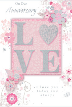 The image shows a refined anniversary card designed in a quiet, romantic palette of pearly whites, powdery blush pinks, and soft silver accents, the kind of gentle elegance a local Tufnell Park florist might pair with a classic rose arrangement. Dominating the centre is the word "LOVE," each capital letter raised from the card and edged with a dusting of fine glitter that sparkles only when the light touches it, giving a tactile, almost embroidered effect. The letters rest on a blush-pink panel that glows against the slightly lighter pink background, creating a subtle frame that draws the eye inward. Surrounding this central word is a graceful spray of illustrated flowers, buds, and curving leaf stems that sweep across the card like a breeze moving through the gardens near Tufnell Park station. The blossoms are stylised rather than photo-realistic, with slender outlines in white and hints of silver foil that catch highlights, reminiscent of the delicate pen sketches many florists use when planning anniversary bouquets. Fine vines and filigree curls weave between the flowers, giving the card a sense of movement and celebratory lightness without feeling busy. In the lower portion, a heartfelt anniversary message appears in a flowing script, its grey lettering soft but legible, echoing the sincerity of a handwritten note delivered alongside fresh flowers along Brecknock Road or Junction Road. The overall impression is of a card that combines romance and sophistication, an ideal keepsake for a couple marking another year of shared memories in and around Tufnell Park.