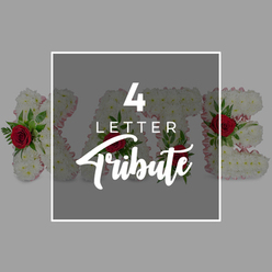 This image presents a refined, contemporary visual for a four-letter funeral flower tribute, the kind of personalised design often requested by families across Tufnell Park and the nearby streets leading toward Holloway Road. In the centre sits a dark slate-grey square with softened transparency, neatly edged in a slim white frame. On this panel, bold white text reads "4 LETTER" in a modern, clear font, while the word "Tribute" appears beneath in a graceful script, echoing the sentimentality of handwritten condolences. Behind and gently breaking out beyond the overlay, four substantial floral letters spell out the name KATE. Each character is meticulously built from a close-knit bed of pure white chrysanthemums, their rounded petals creating a plush, almost cloud-like texture that conveys purity and peace. The sides of these letters are trimmed with a fine pale pink ribbon or fabric, which peeks through the blooms like a soft blush at the edge of a page. Scattered thoughtfully throughout the white flowers are deep red roses, their velvety heads surrounded by sprigs of fresh green foliage, likely fern fronds or ruscus leaves, adding structure and a vivid contrast of colour. The background beyond the framed central design is a calm, light grey expanse, free from distraction so that the tribute and wording remain the sole focus. The composition suggests a handcrafted memorial arrangement available for local delivery, designed to spell out a name or meaningful word, offering a dignified, heartfelt way for Tufnell Park families to say goodbye and keep a loved one's memory visually present during the service.