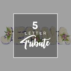 A thoughtfully designed five-letter floral tribute is laid out horizontally against a muted light grey backdrop, evoking the quiet atmosphere of a Tufnell Park farewell service. The individual letters, large and clearly defined, are completely covered in layers of crisp white chrysanthemums or carnations, the blossoms closely packed to create a velvety, cushion-like surface that looks both soft and immaculate. Each floral letter is edged with a band of deep purple satin ribbon, the sheen of the fabric catching the light and providing a refined, solemn outline that gently frames the pure white flowers. Delicate accents of colour appear where clusters of pale pink and dusky mauve spray roses have been carefully wired into place, accompanied by fronds of glossy green fern and small foliage shoots, adding natural depth and a tender, romantic note. Across the middle of the image, a square panel of slightly darker grey overlays part of the arrangement, bordered in white and inscribed with the words "5 LETTER Tribute": "5 LETTER" in a clear, sans-serif font stacked above "Tribute" in elegant script. This overlay partly obscures the letters "J," "O," "H," and "N," with an "A" visible toward the right, subtly demonstrating how a name can be spelled out in flowers. The tribute feels personal and respectful, the kind of customised memorial design often chosen by families in Tufnell Park and along nearby streets for funerals, cremations, and celebration-of-life gatherings where a loved one's name is central to the goodbye.