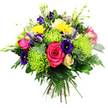 A richly coloured, hand-tied bouquet of mixed flowers is shown against a bright white background, its many hues combining in a joyful burst reminiscent of the lively streets around Tufnell Park and nearby Kentish Town. The bouquet is tightly gathered into a rounded shape, with each bloom nestled closely against the next to create a dense, luxurious dome. At its core sit full, hot pink roses, their velvety petals unfolding in soft spirals that suggest generosity and affection. Lime green spider chrysanthemums surround and intersperse these roses, their long, fine petals shooting out in airy spikes, giving the arrangement a playful, modern edge and a vivid chartreuse glow. Deep indigo and royal purple lisianthus blooms thread through the design, their ruffled, bell-shaped petals and slender buds providing an elegant, slightly formal contrast to the more exuberant flowers. Between them, bright yellow Gerbera-style flowers shine like small suns, their daisy faces bringing a light-hearted, cheerful energy. A solitary cream or pale yellow rosebud nestles shyly near the lower portion of the bouquet, still tightly closed and adding a quiet, romantic note. Small filler flowers in pastel pink and soft lavender peek out here and there, softening the transitions between the main blooms. Rising above the dome, slim green buds and stems introduce vertical movement and a sense of new growth. The entire composition is supported by an abundance of rich green foliage, including feathery fern fronds and smooth eucalyptus-type leaves that fan out and frame the flowers. The bouquet feels freshly arranged and thoughtfully balanced, an ideal mixed-colour gift for sending congratulations, birthday wishes, or simple joy to homes and offices across Tufnell Park.