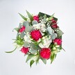 A lush, rounded bouquet is photographed from directly above against a bright white background, every colour and texture clearly defined as if laid out on a clean studio table in Tufnell Park. At the heart of the design, large hot pink carnations unfurl their finely ruffled petals, each bloom densely packed and velvety, creating a sense of movement and fullness. Between them, deep pink and fuchsia roses sit at different stages of opening, some tight and promising, others fully spiralled, showing off their classic layered form. Clusters of small white spray chrysanthemums and other daisy-like flowers settle like soft snowdrifts among the pinks, their many slender petals forming neat, cushiony domes. Wisps of white baby's breath thread through the bouquet, their tiny blossoms catching the light and adding an airy, cloud-like halo. A few slender white buds, reminiscent of alstroemeria or lily-like blooms, stretch upward with understated elegance, suggesting purity and calm within the lively palette. Around the flowers, generous greenery creates structure and depth: rounded, silvery-green eucalyptus leaves with a smooth, waxy sheen mingling with brighter, elongated foliage. At the outer edge, darker, broader green leaves, likely folded aspidistra, wrap around the arrangement like a tailored collar, giving it a polished, professional frame that a local florist near Tufnell Park Underground Station might carefully craft. The overall impression is fresh, joyful, and celebratory, as though prepared for a birthday, congratulations, or a heartfelt thank-you delivered to a townhouse on Fortess Road. The crisp lighting and uncluttered white background keep the focus entirely on the interplay of hot pink, white, and green, showcasing both the natural beauty of the blooms and the meticulous hand-arranging that went into this exuberant bouquet.