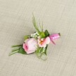 Nestled atop a neutral, woven linen background with a subtle sand-beige hue, this handcrafted floral boutonniere beautifully blends Tufnell Park artistry with wedding-day sophistication. The centrepiece is a tightly curled pink rose, its outer petals soft and muted, sheltering a vibrant magenta-pink core-an image of early-morning freshness. It is complemented by a peachy-pink alstroemeria, its open bloom laced with sunny yellow flashes and gentle, burgundy lines, invoking the colours of the local farmers' market. Sprays of white baby's breath mingle with bright green mini-mums, offering delicate detail and springtime vitality. An array of foliage-both spiked and broad-fans out with careful balance. One glossy green leaf wraps gracefully around the base, binding sturdy stems, their neat finish accentuated by a fuchsia satin ribbon tied into a lively bow. The arrangement is brightened by soft daylight, the interplay of fabrics and floral textures creating a harmonious composition. Designed for the groom or a cherished guest at a Tufnell Park wedding or formal event, this boutonniere channels a mood of gentle celebration and artistic integrity, as if it were picked fresh from a hidden garden off Fortess Road. Refreshing, romantic, and locally inspired, it is both a statement of refined taste and a nod to the welcoming spirit of Tufnell Park's community floral tradition.