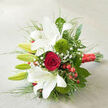 Set on a pale, subtly woven surface that might be a linen cloth on a Tufnell Park townhouse table, this hand-tied bouquet is captured on a gentle diagonal, as though just placed down after a ceremony. Dominating the composition are white oriental lilies, some fully open to reveal their trumpet-shaped blooms and fine reddish speckles, others poised in sleek green buds that promise more fragrance in the days to come. The lilies' petals curl softly, almost satin-like, catching the natural light that streams in as it might through a window overlooking Tufnell Park Gardens. At the centre, a single, perfectly formed deep red rose holds its ground, petals spiralling inward with velvety richness, conveying a strong sense of devotion and timeless romance. Around it, two distinctive spheres of Green Trick dianthus offer a modern, tactile touch, their bright green, tufted texture standing out against the smooth whites and reds. Scattered throughout, airy sprigs of gypsophila appear like a fine mist, while clusters of vivid red hypericum berries add small bursts of colour and a slightly wintery charm. The stems are gathered with intention, wrapped neatly in a wide, glossy red satin ribbon that glows gently against the neutral background, suggesting care, celebration, and unity. Dark green foliage and slender, grass-like strands fan out from the core, giving the bouquet a sense of movement, as if caught in a soft breeze drifting down from Hampstead Heath. The whole arrangement feels thoughtfully balanced and expertly crafted, perfect for a Tufnell Park wedding, a romantic delivery to a home near Junction Road, or an elegant anniversary surprise.