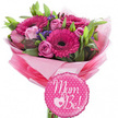 A radiant pink maternity bouquet with a matching Mum to Be balloon is captured against a stark white backdrop, highlighting every colour and curve as though it were about to be handed over at a baby shower in one of Tufnell Park's cosy homes. At the top of the design, a cluster of fuchsia gerbera daisies draws the eye, their bold petals arranged in precise rings around dark, textured centres, giving the arrangement a lively and modern feel. Tucked between the gerberas are gentle, pastel pink roses, some still held in tight buds and others beginning to open into layered rosettes, conveying softness and tender emotion. Light sprays of fine purple filler flowers are scattered among the larger blooms, lending airy texture and a hint of cool contrast that keeps the palette from feeling too sweet. Rich green foliage appears at the edges and between stems, adding natural structure and a freshly cut look, as if the bouquet had just been prepared by a local florist for same-day delivery along Brecknock Road. The stems are hidden beneath a generous collar of pink tissue in varying intensities, from blush to bright candy tones, all embraced by a clear, glossy cellophane wrap that gives the gift a polished, professional finish. Resting at the front and slightly below the flowers, a small round foil balloon with a scalloped edge echoes the bouquet's colour story in vibrant pink, dotted with crisp white spots. Across its surface, the phrase Mum to Be! is written in graceful white script, with a delicate heart-within-a-heart motif adding a final loving flourish. The overall scene communicates joy, anticipation, and celebration of new life, ideal for congratulating an expectant mother anywhere across Tufnell Park.