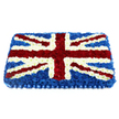 This image shows a substantial rectangular floral tribute styled as the Union Jack, created entirely from densely packed fresh flowers that mimic the fabric and form of a national flag. The design is faithful and bold, with deep blue blossoms laid down first to form a smooth, velvety field that fills the entire background. On top of this, crisp white flowers run vertically and horizontally across the centre, forming the unmistakable cross of St George with clean, straight edges that divide the flag into four distinct quadrants. Diagonal stripes of vivid red blooms then cut across these white paths, standing in for St Patrick's Cross, each red line carefully edged with slim borders of white petals so that every intersection keeps its clarity. The overall effect is of a soft, cushioned banner, slightly raised in the middle, with subtle shadows and highlights adding depth when light brushes over the petals. Around the bottom edge, a pleated, satin-like blue ribbon is pinned neatly in place, its gentle shine framing the flowers and lending a formal, almost regimental finish to the piece. The tribute feels dignified and deeply respectful, perfect for a funeral or memorial service where the individual's British identity or service is central to their story. It is the kind of patriotic arrangement a local Tufnell Park florist might deliver to churches and crematoriums across N7 and N19, bringing a sense of unity and shared remembrance to families gathered from nearby streets like Junction Road and Fortess Road. Through colour, craftsmanship, and texture, the tribute quietly honours a life lived with pride and connection to country.