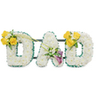 A deeply felt, three-dimensional memorial spelled in large freestanding capital letters that read DAD, each letter formed from a dense, cloud-like bed of pristine white spray chrysanthemums that give the faces a soft, uniform texture. The outer and inner edges of every letter are neatly trimmed with a ruffled, dark green satin ribbon that catches the light and provides a crisp, comforting outline against the white blooms. Behind the letters thin, dark green metal support bars are visible, running horizontally to connect and steady the trio so they present as one cohesive tribute. The left D is accented on its upper curve with a cheerful cluster of three or four bright yellow roses, their petals sunlit in tone, tucked into small sprays of white freesias and delicate gypsophila, with fresh green foliage and two long, slender bare stems arcing upward and toward the centre of the composition. The central A carries a quieter, dignified cluster low on its diagonal arm: two deep purple or burgundy calla lilies whose elegant trumpet shapes offer a refined, reverent focal point, surrounded by tiny white filler blooms and glossy greenery. The right D mirrors the left with a matching cluster of yellow roses and white accents, creating balance and a visual conversation across the piece. Laid against a plain white backdrop and lit softly, the tribute reads as both a statement of respect and a gentle, fragrant farewell. As a local florist piece suited to funeral chapels around Dartmouth Park and nearby north London gathering spaces, it combines craft, texture and colour to comfort and honour a beloved father.
