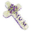 A quietly reverent cross-shaped funeral tribute laid against a stark white backdrop, its silhouette defined by a dense carpet of snow-white chrysanthemum heads packed closely to form a pillowy, gentle surface. Around the outer edge a ruffled purple satin ribbon weaves a soft border, the lilac-to-deep-violet tones catching the light and framing the piece with solemn dignity. Down the vertical arm the word MUM is lovingly spelled in smaller, rich purple flower heads - likely eustoma or small spray chrysanthemums - each letter standing out clearly against the white foundation to give the arrangement an unmistakably personal message. At the centre, where the arms meet, a lush focal spray gathers deep violet roses and paler lavender lisianthus, their velvety petals and ruffled edges layered for depth, while variegated foliage with lighter margins and darker centres nestles among them to add a cool, natural contrast. Small green berries peek through the cluster, lending subtle texture and a hint of life amid the more contemplative hues. The overall palette of pristine white and graduated purples evokes purity, peace, and quiet mourning; the soft density of the blooms suggests a comforting embrace. There is a faint, powdery scent as if of spring rain on a garden path, and the composition reads as both classic and tender - an arrangement designed to bring calm and a heartfelt farewell at a wake, graveside service, or memorial reflecting the gentle respect often asked for in Tufnell Park family tributes.