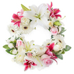 This image shows a beautifully full, open circular wreath arranged as a dignified funeral or memorial tribute, photographed against a bright white background that lets every flower stand out clearly. The wreath is composed of a harmonious mix of white, blush pink, and vivid magenta blooms, forming an unbroken ring that symbolises continuity and eternal love. Large white Oriental lilies appear throughout, their smooth petals gracefully flared and their central stamens touched with warm golden pollen, suggesting peace and spiritual calm. Around them, deep pink and fuchsia lilies add a richer note of colour, their star-shaped blossoms and lightly speckled petals creating a feeling of movement and gentle energy. White gerbera daisies with dark central discs sit between the lilies, their evenly spaced, layered petals bringing a crisp, modern texture. Clusters of soft pink roses and classic white roses, some fully open and others still in tight buds, weave a romantic thread through the design, echoing memories of affection and family gatherings in the quiet streets near Tufnell Park. Smaller white flowers, reminiscent of miniature carnations or delicate spray chrysanthemums, fill the spaces, softening transitions and giving the wreath a plush, velvety volume. All of these blooms are supported by a generous base of fresh green foliage, with varied leaves and subtle hints of new growth adding depth, shape, and a natural frame. The overall mood of the piece is calm and reverent, a tasteful choice for paying respects at a funeral service or celebration of life in the Tufnell Park area, offering comfort through its gentle colours and thoughtful craftsmanship.