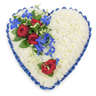 A top-down view reveals a generously sized, heart-shaped sympathy tribute designed with the quiet elegance often requested by families in Tufnell Park for funeral services and wakes. The heart is densely packed with white chrysanthemums, their small, tightly layered petals forming a thick, plush bed that looks soft to the touch, evoking purity and peace. Around the outer edge, a royal blue satin ribbon has been carefully pleated and ruffled, its rich colour framing the heart and adding a refined, almost ceremonial note as it catches faint highlights. On the upper left curve, an asymmetrical spray of flowers forms the main visual focus. Here, three deep red roses in full bloom rest among dark green leaves, their velvety petals unfurling in generous spirals. From this cluster, slender stems of bright blue dendrobium orchids trail diagonally towards the centre, their star-shaped blooms creating a vivid ribbon of colour that contrasts beautifully with the white base. Light green curly tendrils twist playfully among the orchids, giving movement and a natural softness. On the lower right edge of the heart, a solitary red rose has been positioned with care, reflecting the main cluster and suggesting one special person remembered. The overall mood is dignified and reflective, with no distractions in the background. This floral heart, the kind that might be delivered by local florists to chapels and crematoria serving Tufnell Park and neighbouring Kentish Town, eloquently combines white, blue, and red to symbolise innocence, devotion, and calm remembrance on a day of goodbye.