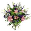 Set against a crisp white backdrop, this hand-tied bouquet reads like a quiet walk through a springtime garden in Tufnell Park. At its center several pale, antique-pink roses sit in varying stages of bloom - some tightly furled, others with petals softly unfurling to reveal slightly darker pink edges - their velvety faces drawing the eye. Two full, dusty-rose or mauve-pink carnations add soft ruffled volume and a gentle, watercolor-like shading to the composition. Vertical spikes of deep indigo to violet Veronica thrust upward, providing arresting contrast and a slender architectural line through the rounded blooms. Scattered between these are clusters of tiny lavender-blue aster-like flowers with small, sunny yellow centers that give the bouquet an airy, meadow-like lightness. Deeper jewel tones arrive in the form of rich purple eustoma (lisianthus) blooms and buds, their satin petals punctuating the palette and offering visual depth. The arrangement is nourished by a variety of foliage: rounded, silvery-green eucalyptus leaves lend a cool, soft sheen; bright lime-green textural filler - suggestive of viburnum or Santini chrysanthemum clusters - lends a fresh, almost dewy contrast; and slender green leaves and new buds tuck in between flowers for an organic, hand-gathered feel. The stems are visibly gathered at the base, confirming a loose, artisan hand-tied construction that breathes and moves. Soft, natural lighting lifts the pastels and deep tones equally, while an almost imperceptible green-leaf fragrance suggests morning outdoors. This bouquet feels celebratory yet intimate - a thoughtful gift for birthdays, thank-yous, quiet anniversaries, or to brighten a home with the easy grace of seasonal blooms.