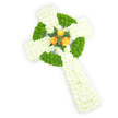 A graceful, three-dimensional Celtic cross crafted entirely from fresh blooms rests against a crisp white background, seen from a slightly raised viewpoint that reveals its depth and sculpted form. The arms and elongated shaft are densely covered in pure white spray chrysanthemums, their tiny petals forming a soft, pillowy surface that reads both comforting and reverent. Woven through that white ground are bands and alternating blocks of bright apple-green button chrysanthemums; their round, cushion-like heads outline the circular ring at the cross's centre and punctuate the horizontal arms, creating the Celtic knot suggestion with clear, tactile contrast. At the precise meeting point of the arms sits a small but luminous cluster of three fully opened orange roses - warm, golden-orange petals that glow like late-afternoon sunlight against the cool white and fresh green. A few sprigs of deep green fern or similar foliage cradle the roses, sharpening the focal point and introducing a dark, natural counterpoint to the pastel brightness. Soft, even lighting highlights the fine textures - the chrysanthemum's feathery profiles, the roses' layered petals - while the white backdrop keeps attention on the craft and colour balance. This arrangement reads as a dignified sympathy tribute or funeral cross, its palette quietly evoking Irish colours without overpowering the serenity of the piece. As a local florist who has prepared many memorials for families around Tufnell Park and Dartmouth Park, I find the composition comforts: a ready-made symbol of remembrance, pastoral calm, and respectful craftsmanship in both form and floral choice.