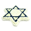 A beautifully composed Star of David floral tribute dominates the frame, set against a pure white background that emphasises its symmetry and clean lines. The entire six-pointed star is created from tightly packed small chrysanthemums and similar blooms, giving the arrangement a plush, textured appearance reminiscent of a soft quilt of petals. A wide, immaculate border of white flowers outlines every point of the star, while the central hexagon and the six inner, inward-pointing triangular shapes are also filled with the same bright white blossoms, creating a calm, luminous centre. Around this central field, two interlocking triangles are expressed in deep navy blue flowers, their rich colour providing a strong, dignified contrast that clearly defines the familiar Magen David shape. The measured combination of white and blue naturally recalls the colours associated with Jewish ritual objects and the Israeli flag, reinforcing the symbol's cultural and spiritual significance. Each bloom appears fresh and carefully placed, as though just completed by a skilled Tufnell Park florist preparing for a Jewish funeral or memorial service somewhere near the green spaces of Tufnell Park Fields. The lighting is soft and even, allowing the texture and depth of the flowers to be easily understood without harsh shadows. This floral Star of David reads as a thoughtful, reverent tribute, designed to honour a loved one's life, faith, and heritage while offering comfort to family and friends gathered in mourning within the close-knit local community.