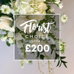 An expansive white and cream spray fills the frame, a lush garden style arrangement that feels both grand and intimate. The bouquet begins with large, softly velvety roses in cream, some petals just unfurling, interwoven with generous clouds of hydrangeas in pale ivory. A gentle cascade of white sweet peas or similar slender blooms threads downward, adding movement and a sense of breeze along the stems, while nigella with its distinctive green centers and wispy petals punctuates the upper masses with delicate texture. The greens are varied and abundant: broad, dark leaves provide a rich backdrop, lighter variegated greens offer contrast, and slender feathery fronds drift from the edges to soften the silhouette. The arrangement sits against a clean, light beige background that makes the whites glow with quiet radiance. A crisp white square overlay sits at the center of the image, bearing Florist Choice Today in a flowing script, followed by SPRAY in a bold uppercase sans serif, and a large treatment of the price in white text. The overall effect is luxurious yet accessible, a premium offering that suits weddings, anniversaries, or a refined home display. From Flowers Tufnell Park, this composition reflects the care of a local florist who knows the neighbourhood routes to deliver across Tufnell Park, Kentish Town, and Holloway on the same day, ensuring freshness and dependable service. The image communicates a sense of calm elegance and thoughtful craftsmanship, inviting the viewer to imagine the fragrance, the soft textures of the petals, and the lasting impression it would make as a tribute or centerpiece.