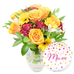 A sunlit, celebratory bouquet sits in a simple clear glass vase, its water and neatly trimmed green stems visible through the transparency, and a cheerful round foil balloon tucked gently to the lower right. The arrangement reads warm and welcoming: peachy-orange and bright yellow roses unfurl in generous spirals, their petals satiny and smelling faintly of honey and warm summer afternoons. Yellow gerbera daisies - flat, sun-like faces with deep brown centres - scatter joyful points of light among the roses. Deep burgundy carnations, densely ruffled and velvety to the eye, add a plush, grounding counterpoint to the lighter blooms. Sprays of white alstroemeria with slender, freckled petals lift the composition with delicate, almost paper-like textures. Glossy broad leaves and slender green sprigs cradle the flowers, giving the bouquet a lush, garden-fresh frame and a soft rustle when touched. The white round Mylar balloon overlaps the lower right of the vase, decorated with scattered gold and fuchsia polka dots and tiny hearts; in the centre, the flowing hot-pink script reads best Mum, a personal, affectionate message. The lighting is soft and even, highlighting the warm tones and the sheen on the balloon without harsh shadows, as a florist might present a gift ready for a special doorway or dining table. This arrangement evokes quiet celebration and gratitude - a tactile, fragrant present that feels handcrafted and thoughtful, ideal for a mother's birthday, Mother's Day, or any occasion when you want to send warmth and appreciation from the heart.